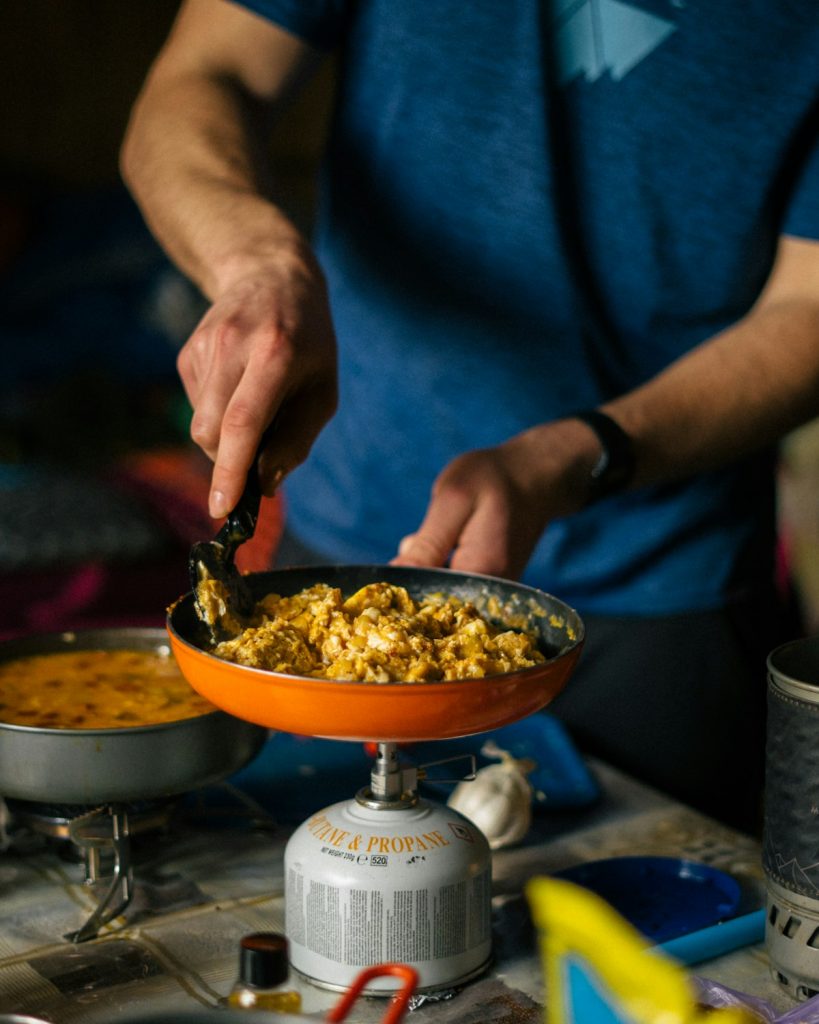 Iemand roerbakt groenten in een wok